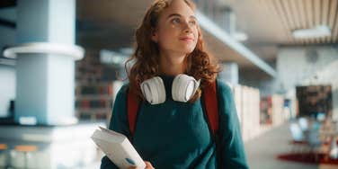 young student wandering through school library