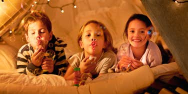 cute kids blowing bubbles in magical fort