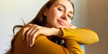 happy emotionally unbreakable woman smiling hugging herself