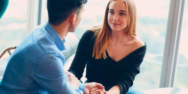man holding hands with his truly intelligent wife at home