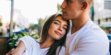 Woman with a husband she's cuddling to show appreciation at a cafe