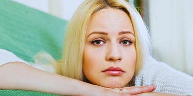 Woman who is always tired but never sleeps looks exhausted on a couch