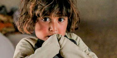 Young child looking at the camera with a thoughtful expression, reflecting how early family environment can shape confidence and self-esteem