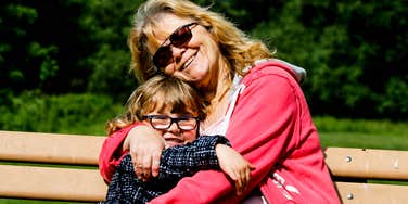 A close-up lifestyle shot showcasing the relationship between a grandmother and her grandchild; illustrating the 'anxiety contagion' concept and the invisible emotional labor required to shield children from generational stress.