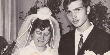  A vintage 1960s black and white photograph of a bride and groom exchanging rings; a visual representation of 'institutional formality' and the old-fashioned marriage ideals that Millennials and Gen-Z no longer believe in.