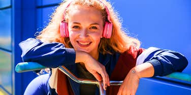 millennial woman leaning on her bike smiling