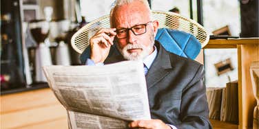 older man reading a newspaper feeling nostalgic for the past