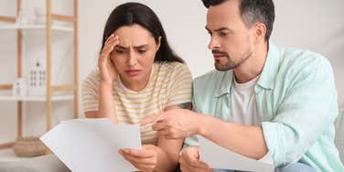 couple stressed looking at bills