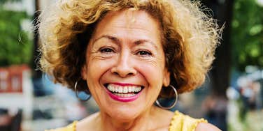 A close-up portrait of an elegant elderly woman looking forward with a confident, joyful smile; illustrating 'emotional agility' and the daily cognitive habits that support deep life satisfaction.