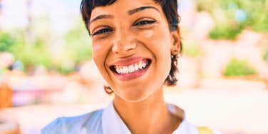 vibrant woman who is impossible to forget smiling outside