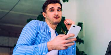 confused gen z man using his phone