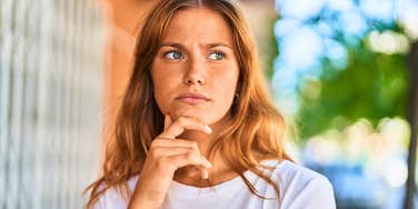pensive woman with zero empathy standing outside