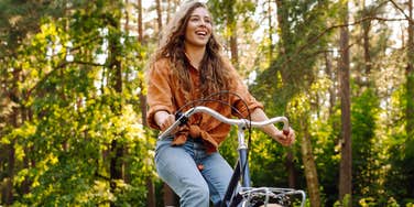 happy woman riding bike outside