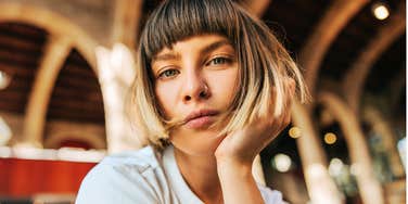 A beautiful European woman with short hair sharing a serene, direct gaze with the camera; illustrating 'intuitive progress' and the quiet, often overlooked psychological shifts that signal genuine personal growth.