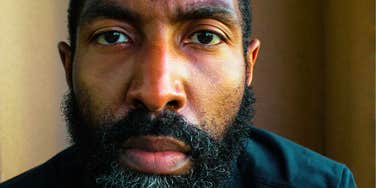 A close-up lifestyle portrait of a bearded man looking away in deep thought; illustrating 'the relational neglect matrix' and the invisible emotional isolation experienced by husbands in struggling marriages.