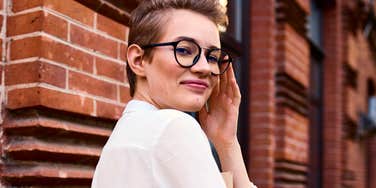 mentally sharp woman smiling by a brick wall