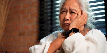 older tired woman struggling with money stress at home