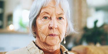 Wealthy older woman looks sternly at camera