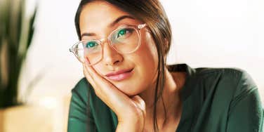 A worried female writer daydreaming at her workplace while struggling with exhaustion; illustrating 'cognitive depletion' and the mental health challenges of navigating modern career pressures and burnout.
