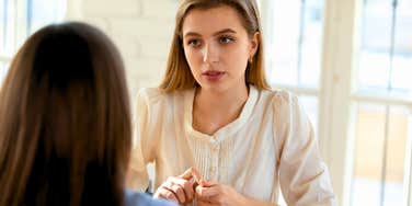 insecure woman having a conversation with colleague