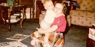 1960s little girl babysitting her younger brother as a chore