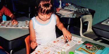 An archival 1980s classroom photograph showing a young student reading at an elementary school desk, symbolizing Gen-X childhood independence and reading culture.