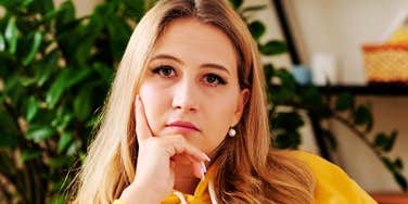 A pensive young woman looking upward thoughtfully, embodying low emotional reactivity, analytical boundary-setting, and calm boundary maintenance against gaslighting.