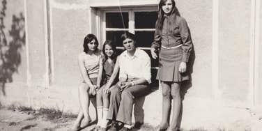 group of teens in the 1970s sitting outside together