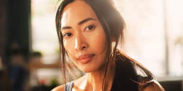 A candid close-up portrait captures a resilient woman. Symbolizing the mental and physical toll of fighting against institutional prejudices.