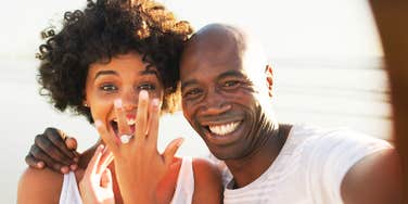 A stylish, confident couple sharing a warm, authentic moment during an engagement, illustrating emotional maturity, mutual ambition, and relational equality.