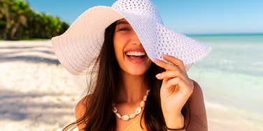 woman born in the summer looking happy on the beach