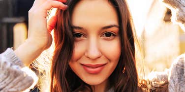 A bright, close-up snapshot of an attentive young woman smiling in natural light, symbolizing mental clarity, emotional poise, and proactive courage.
