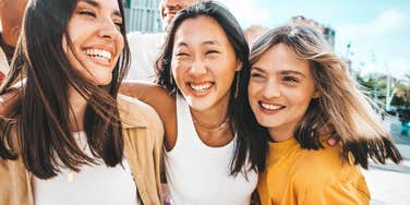 Woman who is great at reading a room embraces her friends and laughs