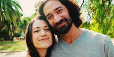 A candid, close-up photograph of a loving couple laughing together outdoors, reflecting long-term relationship satisfaction, emotional maturity, and shared peace.