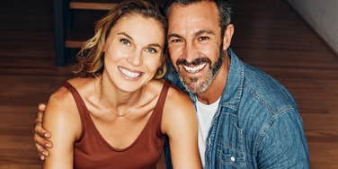 A loving couple sharing a candid moment of affection on their lounge floor, illustrating relationship trust, shared values, and secure emotional attachment.