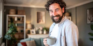 Man who is happy being alone in his house with a cup of coffee