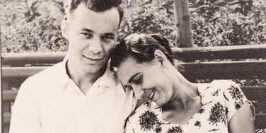 A vintage 1950s black-and-white photograph of a young couple huddled together on a bench in a summer garden; a visual representation of 'the foundational affection' that blooms into lifelong marital success.