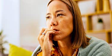nervous woman biting her nails doubting herself