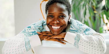 good and honest woman smiling from behind couch
