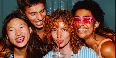A high-energy group of friends laughing and walking together during an evening outing; a visual representation of 'the curated collective' that toxic individuals often use to build superficial popularity.