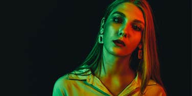 sad young woman feeling guilty in green light