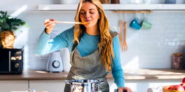 woman who enjoys cooking tasting in her kitchen