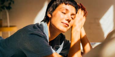 happy woman waking up well rested in a sun beam