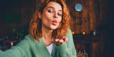 narcissistic woman taking a selfie blowing a kiss