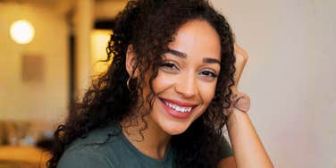A mentally and emotionally strong woman smiling with calm confidence; a visual representation of 'the resilient independent' archetype who embodies inner peace and psychological fortitude.