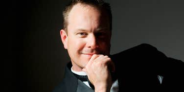 A man dressed in a formal suit and tuxedo looking thoughtfully into the distance, symbolizing commitment, post-divorce transitions, and rapid remarriage.