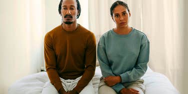 serious unhappy couple sitting next to each other feeling distant