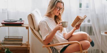 woman feeling cozy at home reading a book to relax