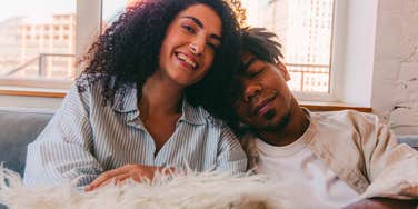 smiling woman sitting next to her ex on the couch