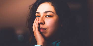 awkward shy woman covering her face